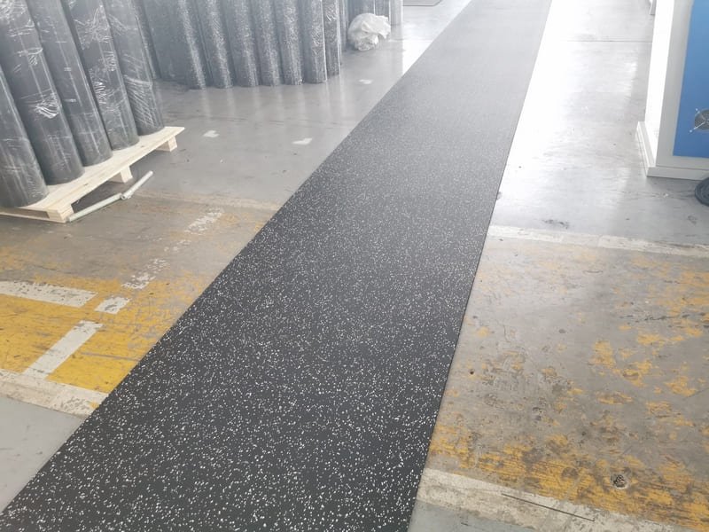 Engineer measuring the thickness and density of a rubber roll floor sample